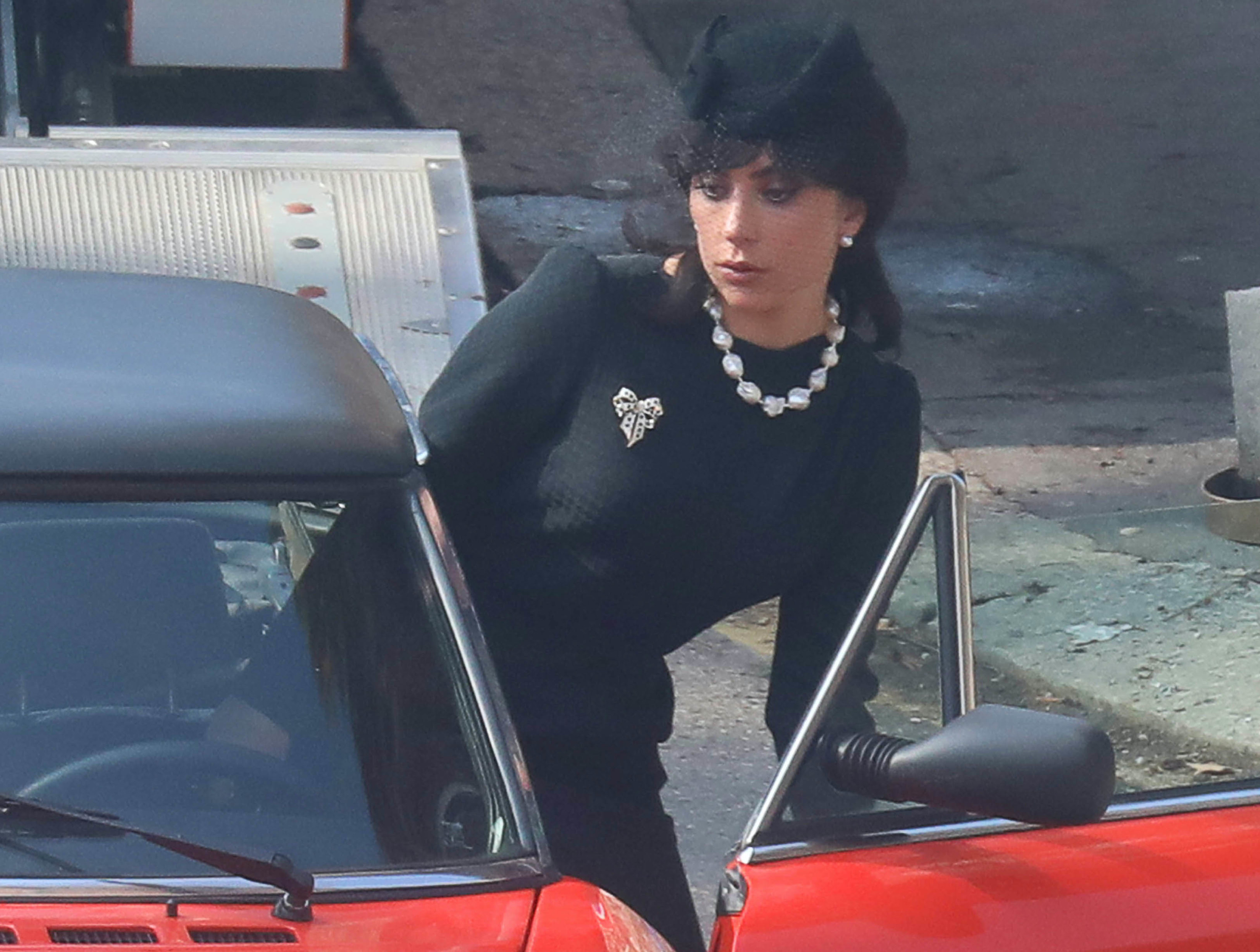 Lady Gaga entering a car in all-black and a veil