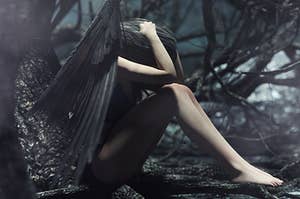 A fairy with dark black wings clutching her head