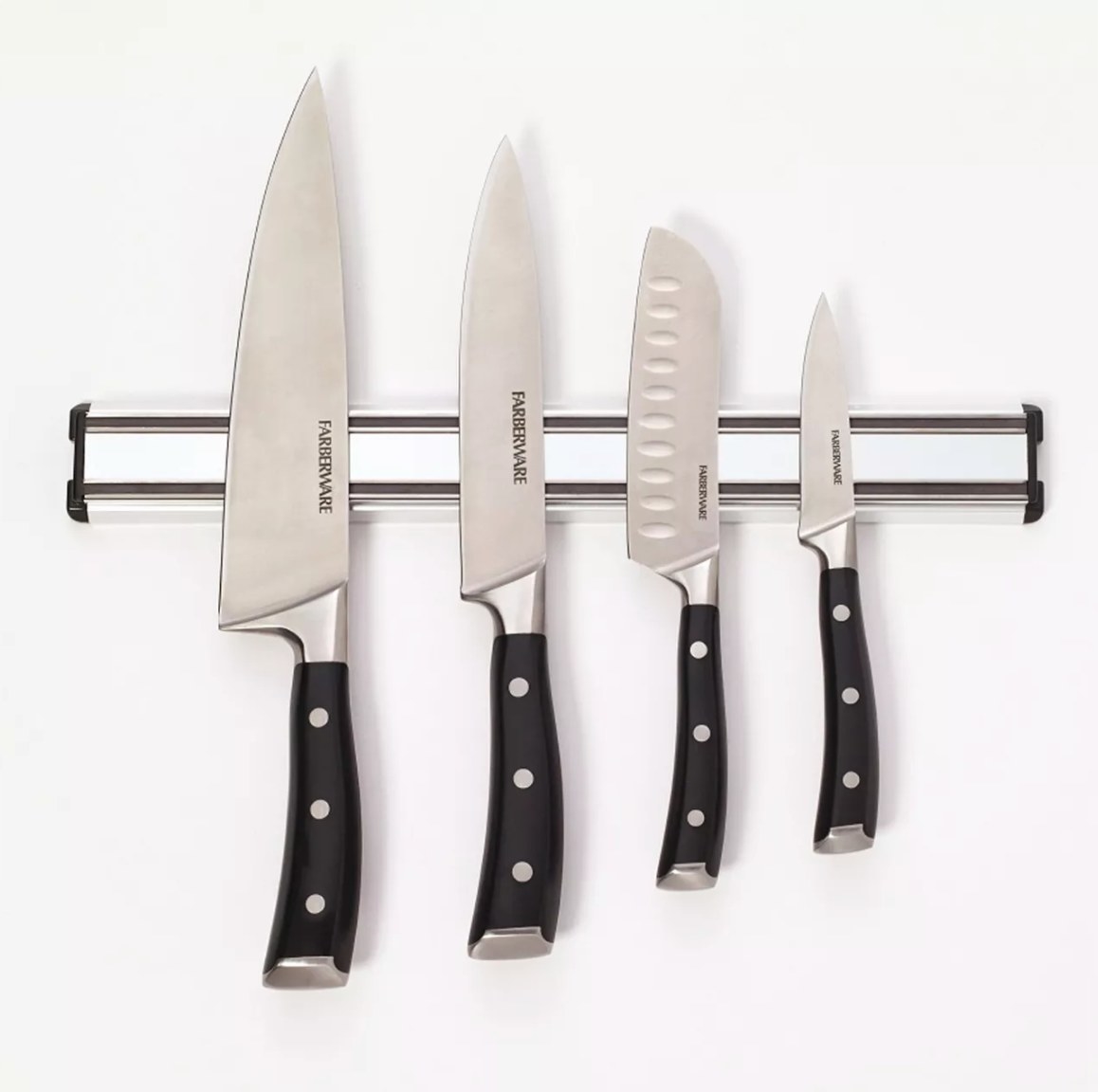 The magnetic knife holder holding a set of four knives with black handles