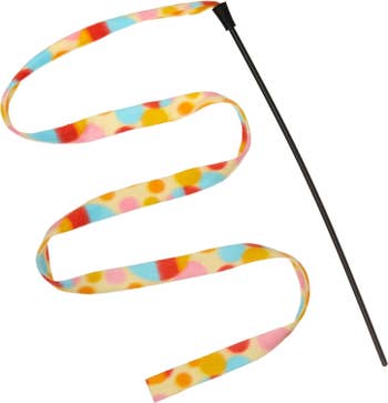 the polka-dotted yellow, pink, and blue strip of fabric on a stick