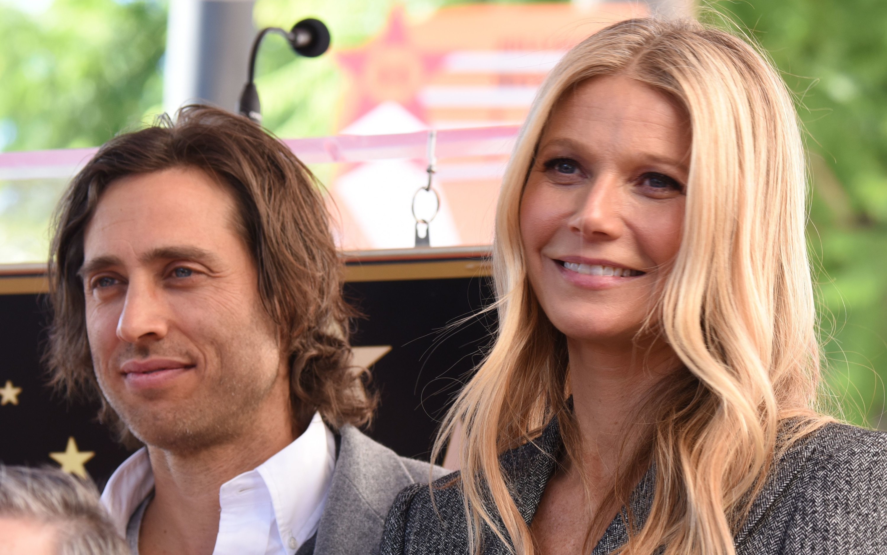 Gwyneth smiles while standing next to Brad at an event