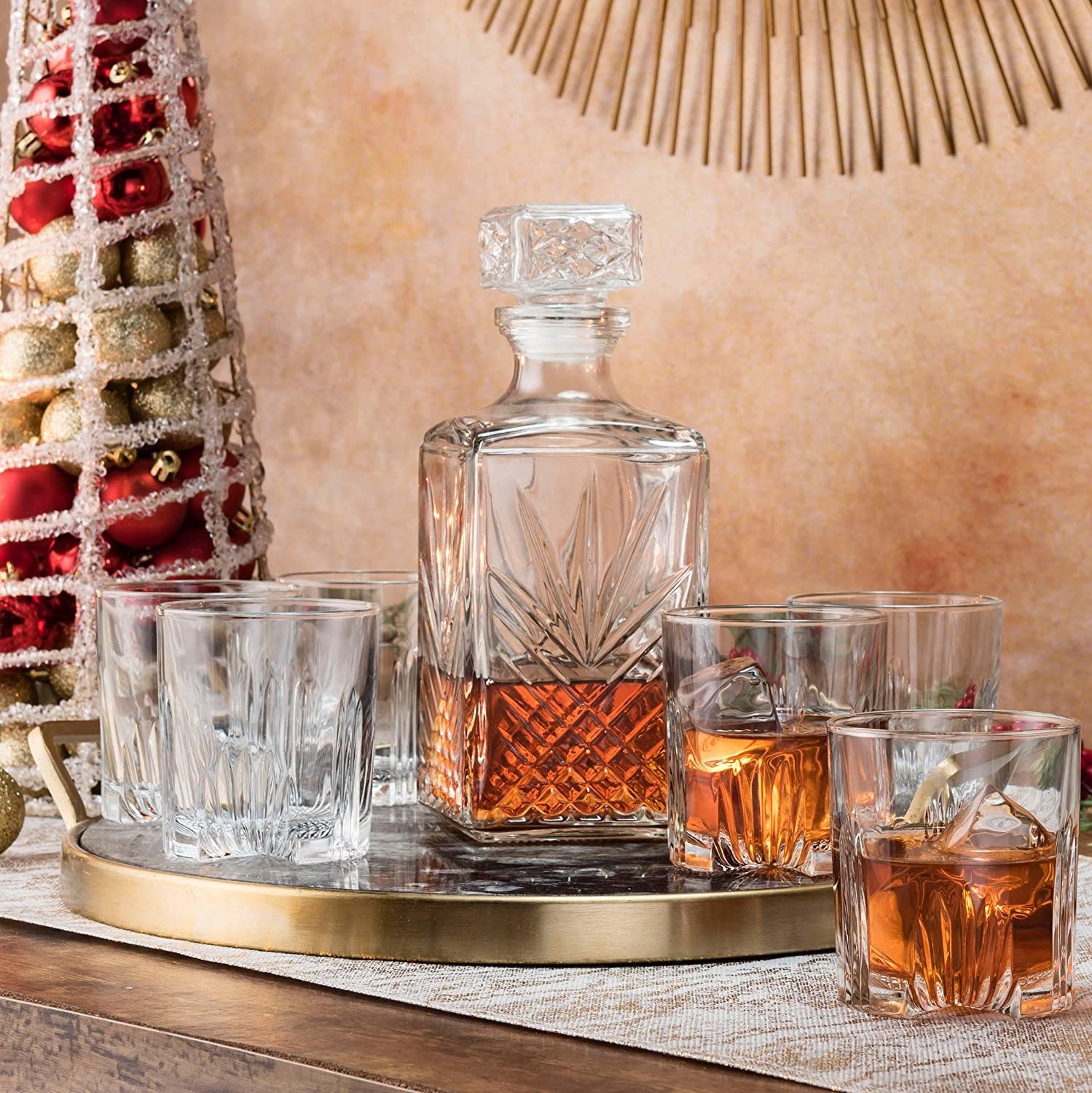 the decanter filled with a dark liquor with the other glasses surrounding it