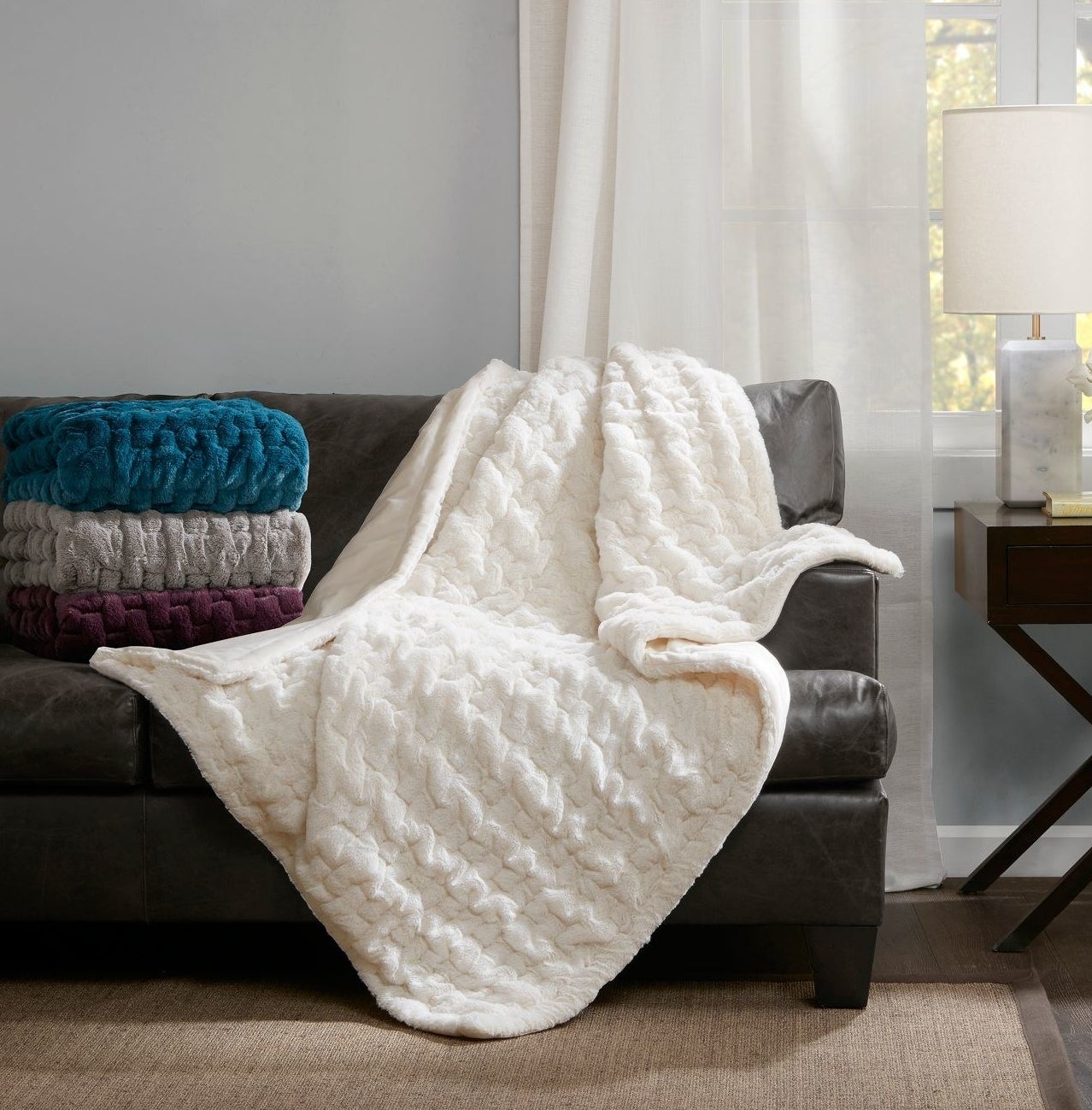 A white throw blanket spread over a couch