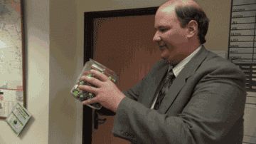 Kevin Malone from The Office pouring M&amp;amp;Ms from a jar into his mouth.