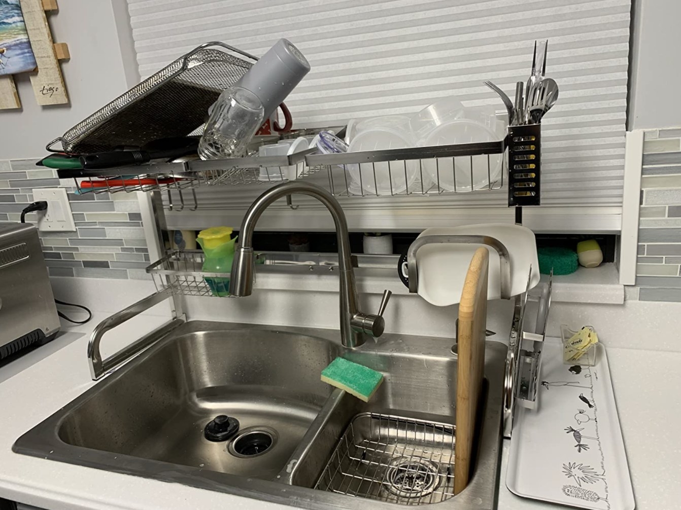 The over the sink drying rack holding dishes in a reviewer&#x27;s kitchen