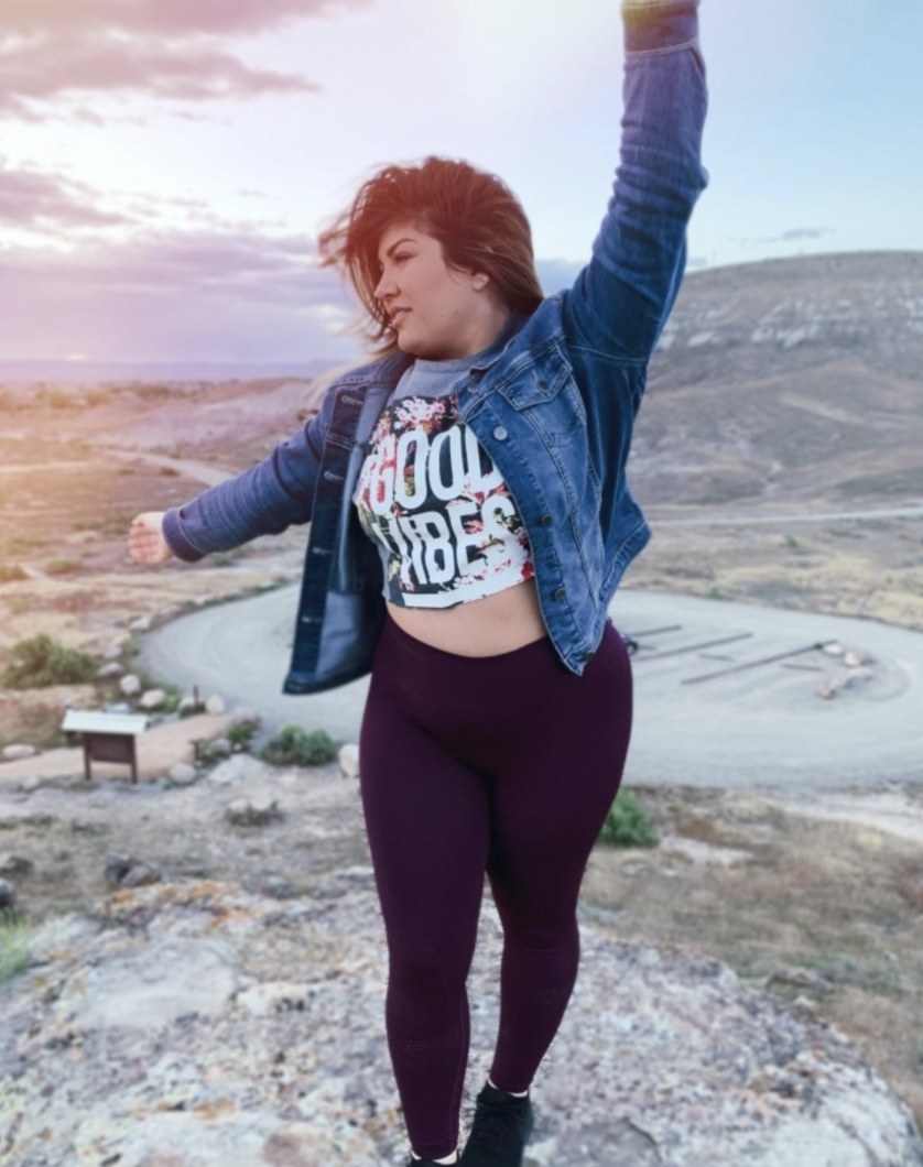 Person is wearing purple leggings, a graphic T-Shirt, and a denim jacket