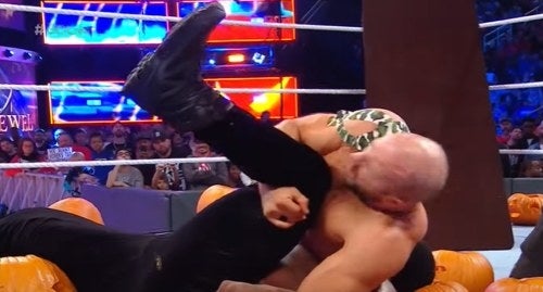 Wrestler Ceasro pinning opponent atop pumpkins.