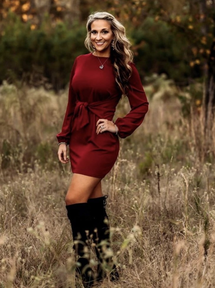 Reviewer photo of a person wearing a wine red knit dress and black boots