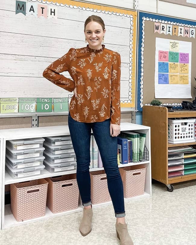 Reviewer photo of a person wearing denim jeans and a burnt orange chiffon blouse