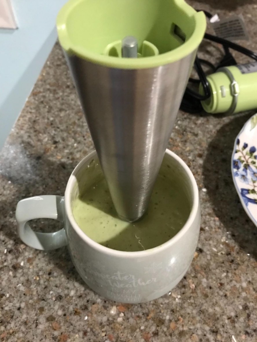 reviewer using the immersion hand blender to make a smoothie in a mug