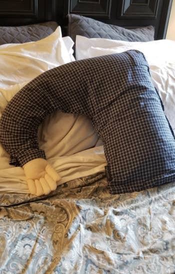 reviewer's boyfriend pillow on their bed