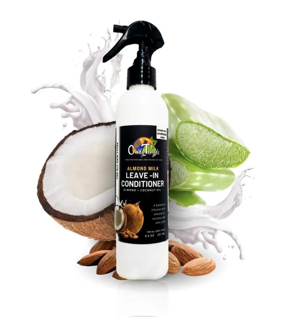 Bottle of leave-in conditioner, surrounded by almonds and coconuts