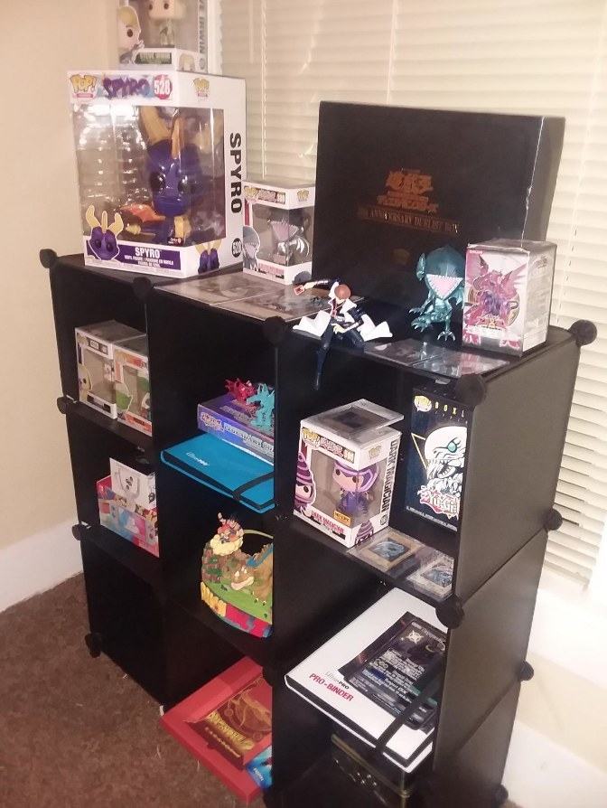 black cube storage bookcase set up three by three holding collectibles