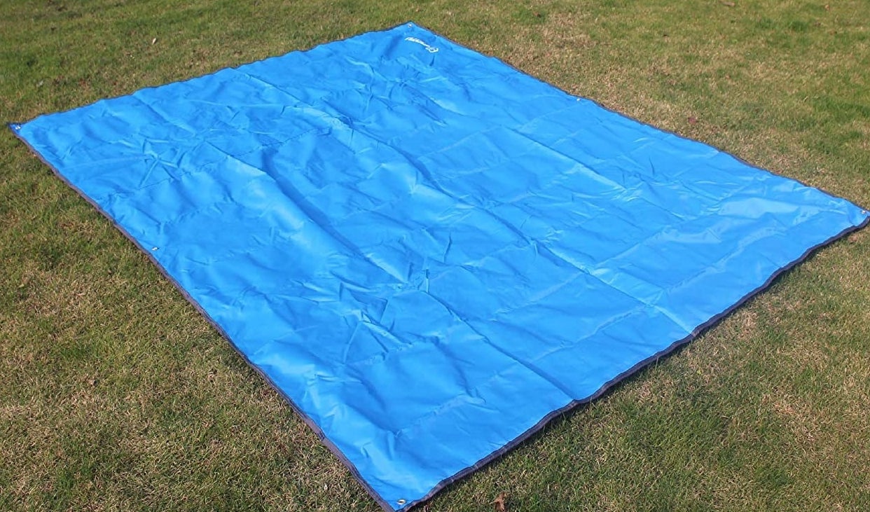 A tarp laid out on some grass