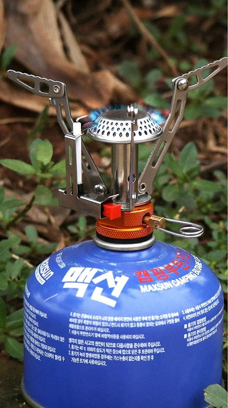 The mini stove attached to a canister of propane