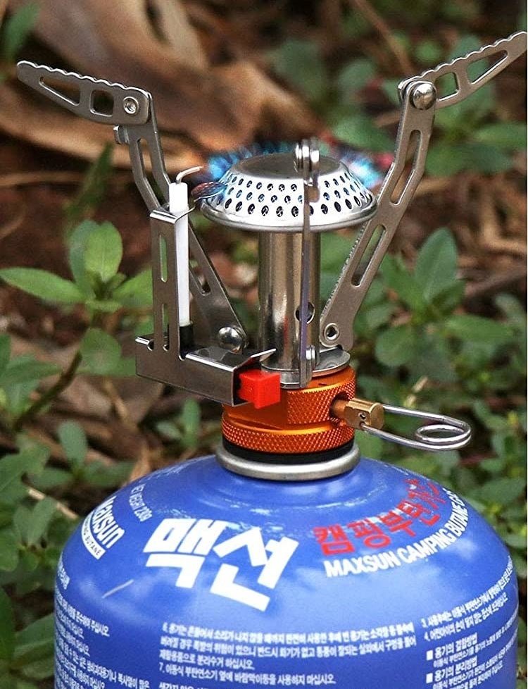 The mini stove attached to a canister of propane 