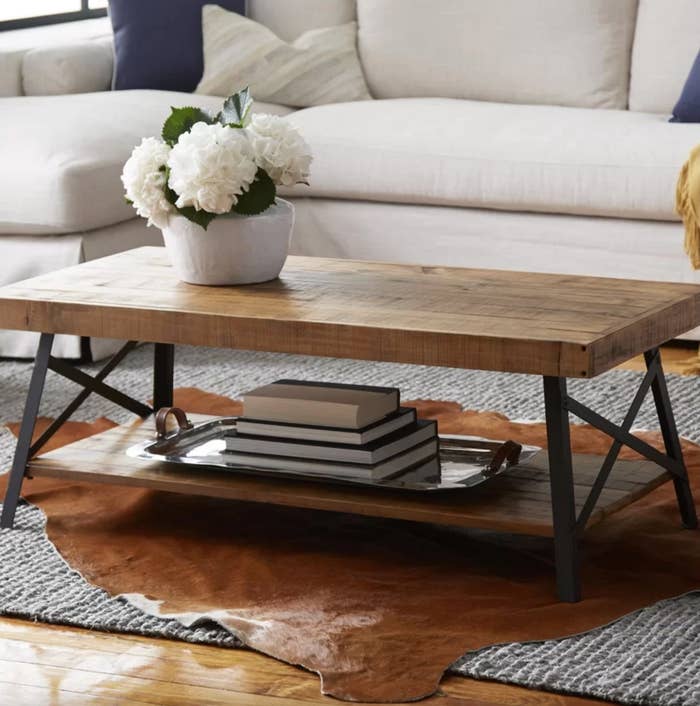 The coffee table with storage in natural pine brown with a vase of flowers on top