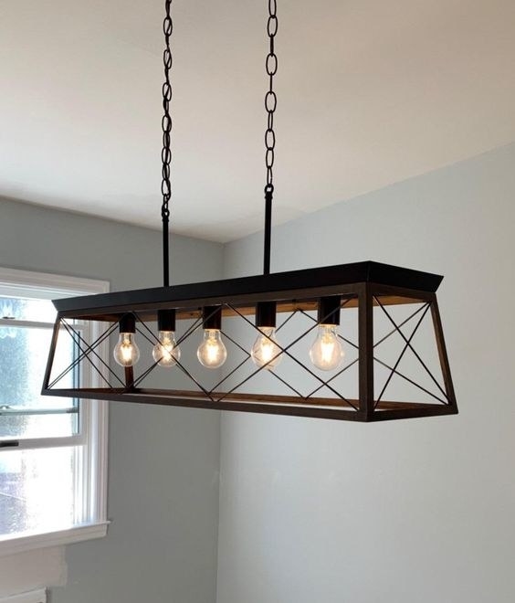 Reviewer&#x27;s picture of the rustic chandelier with traditional lightbulbs 