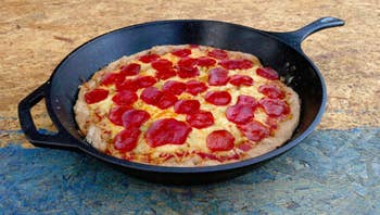 a cast iron skillet cooking a pizza
