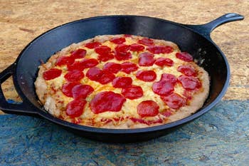 a cast iron skillet cooking a pizza