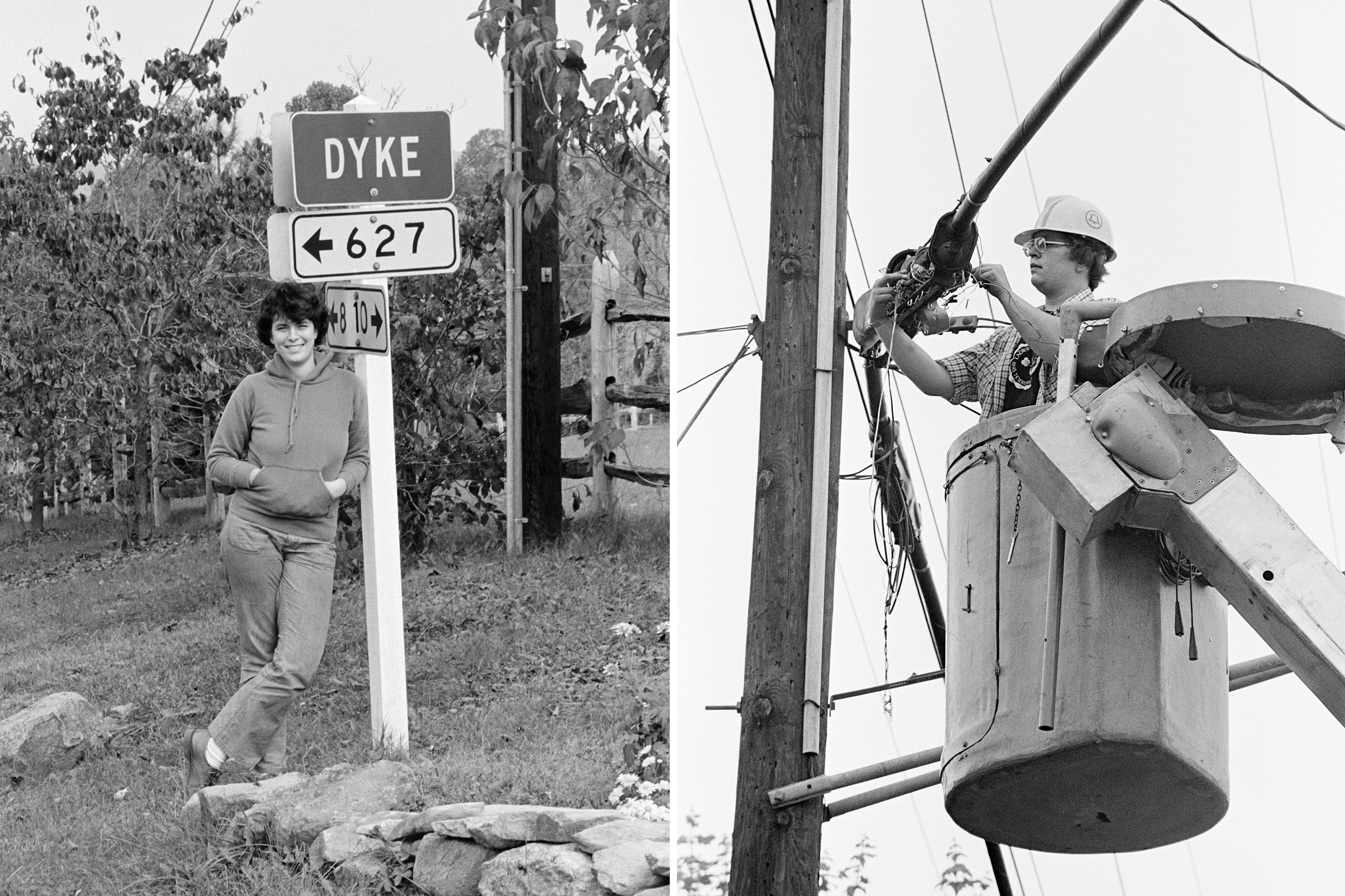 A woman stands in front of a sign saying Dyke and another woman works in a cherrypicker on some power lines