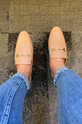 reviewer wearing the buckle-detail loafer mules in tan