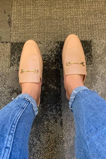 reviewer wearing the buckle-detail loafer mules in tan