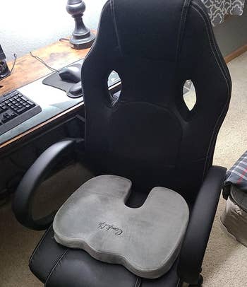 reviewer showing the gray cushion on their office chair
