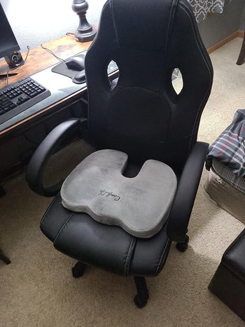 reviewer showing the gray cushion on their office chair