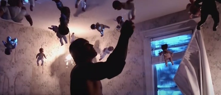 Randy Orton inside a dark room with dangling baby dolls.