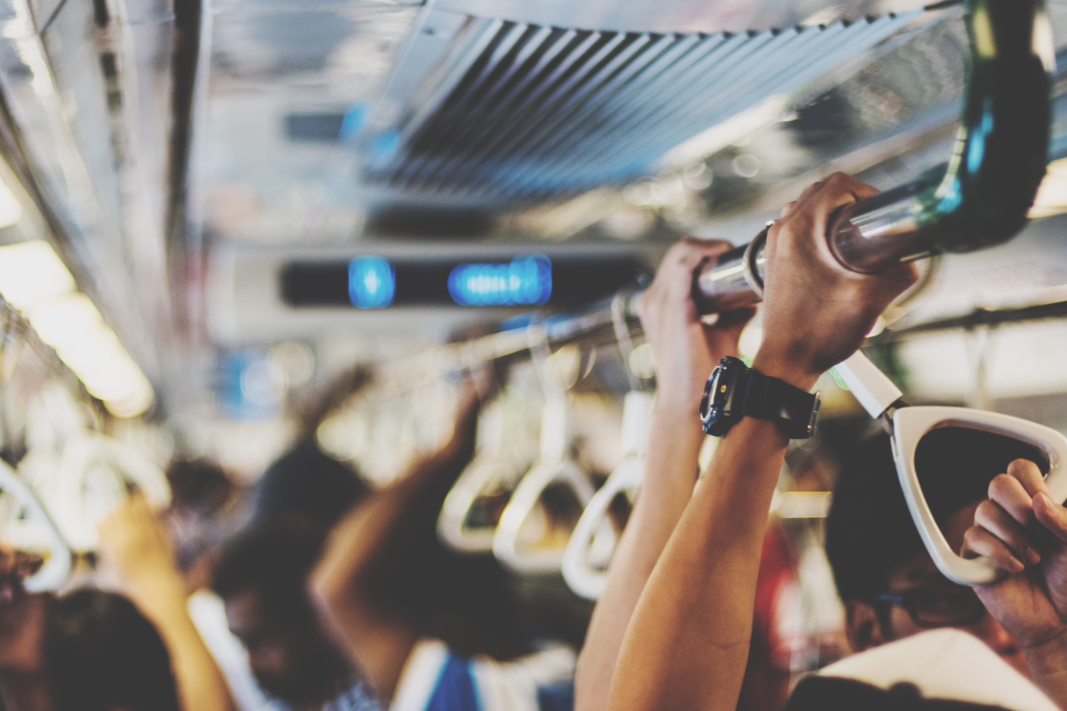 hands on a rail of a public bus