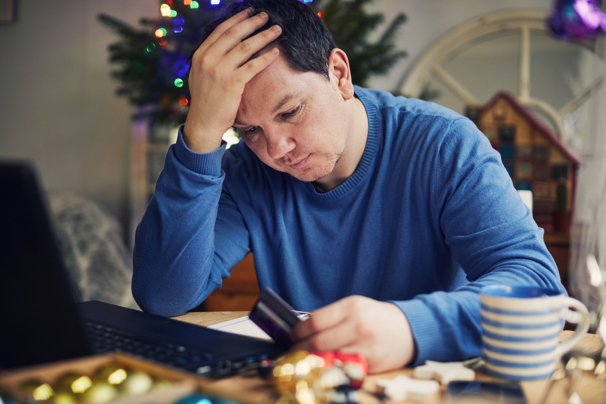 a stressed out man holiday shopping online