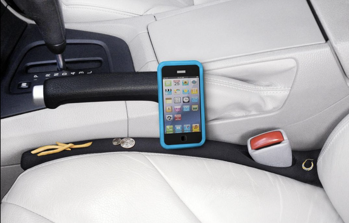 a car gap with phones, change, and fries on it