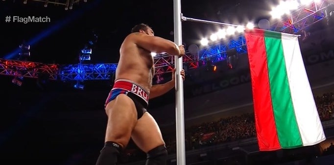 Wrestler Rusev grabbing a Bulgarian flag on a pole.