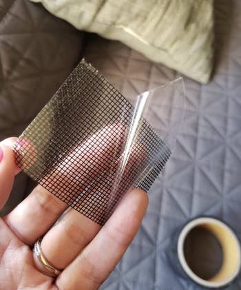 A reviewer holding up a piece of the mesh repair tape 
