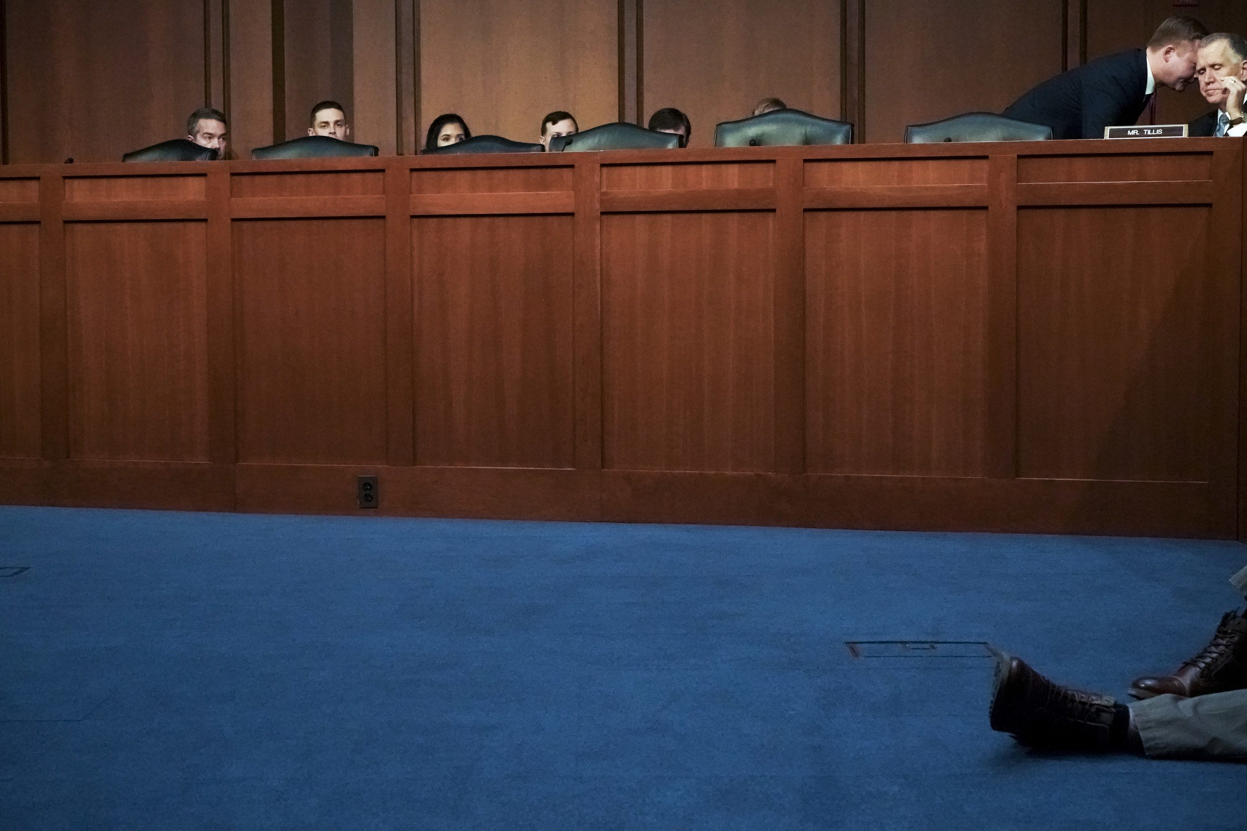 A picture of a man on the floor of the senate, with people&#x27;s heads barely visible over the dais behind him