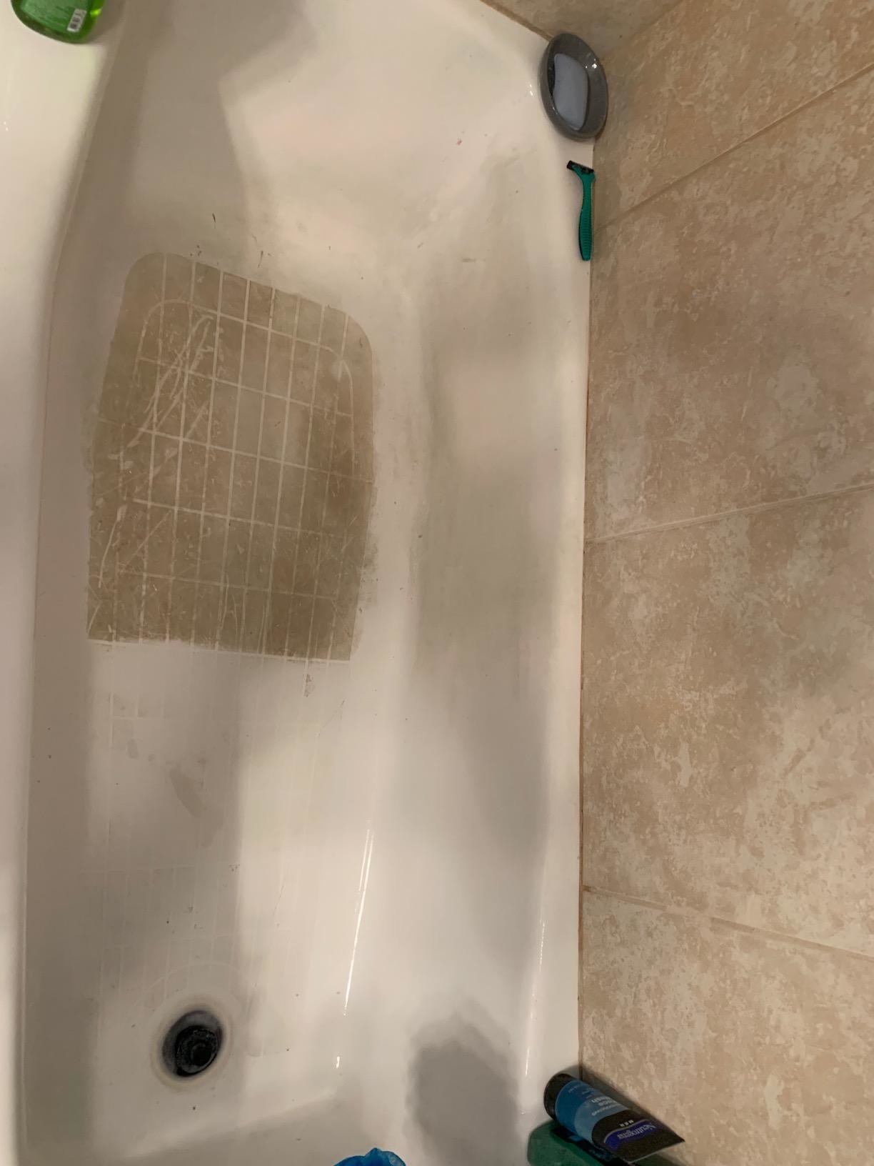 A bathtub half cleaned, half brown with dirt to show the cleaning difference