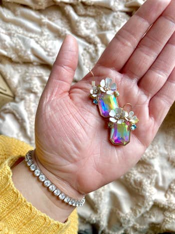 Buzzfeed editor holding the iridescent gem earrings in her hand 