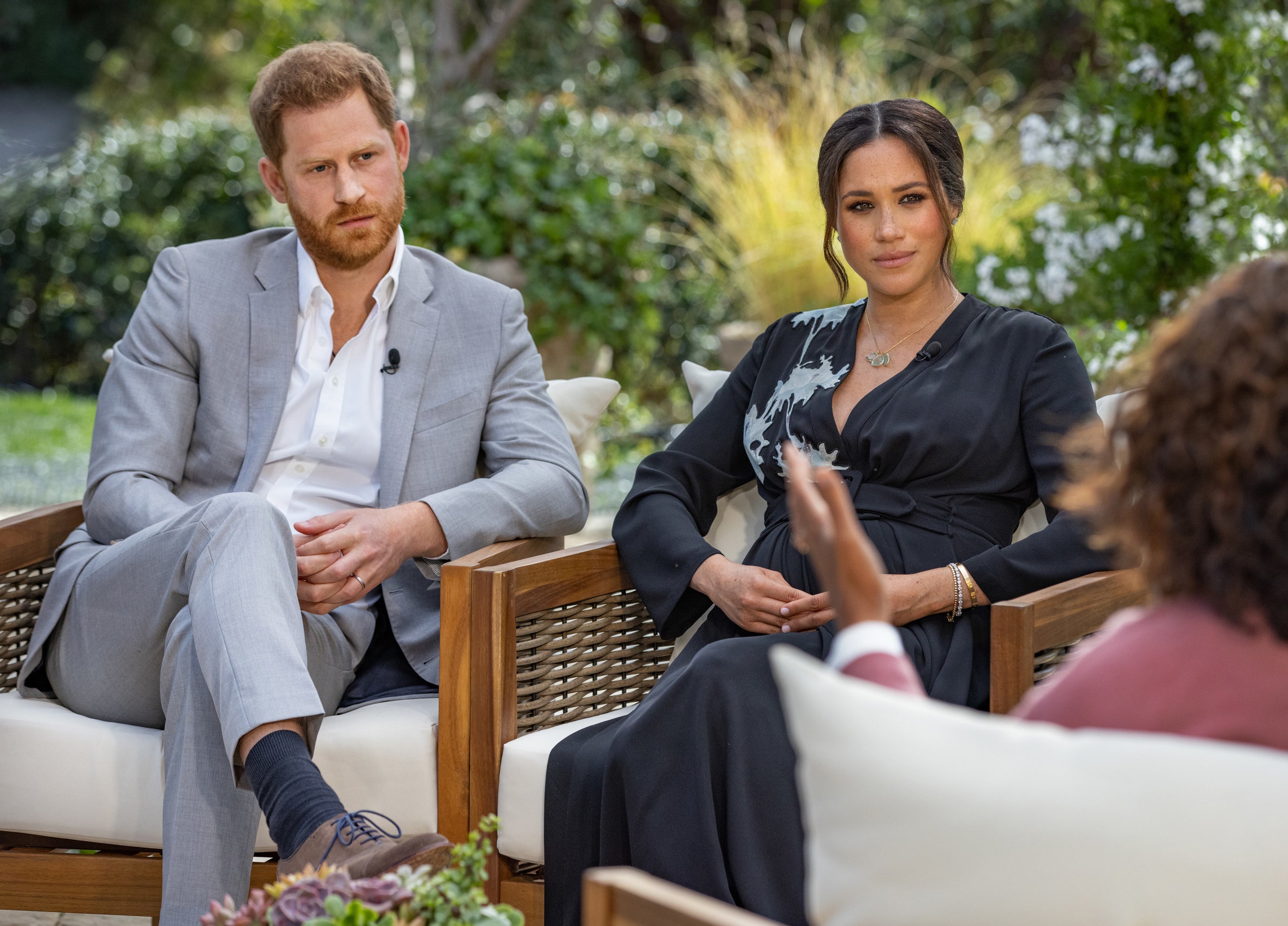 Harry and Meghan intently look at Oprah during the interview