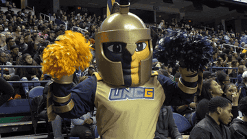 Spartan with a golden helmet, yellow and blue face paint, and pom-poms.