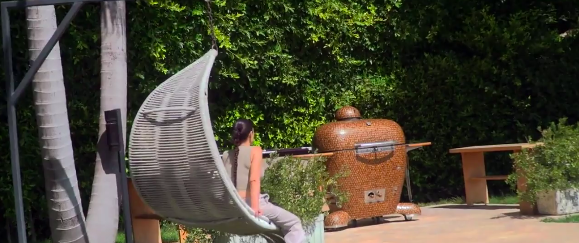 Kim, from behind, sitting in a hanging chair