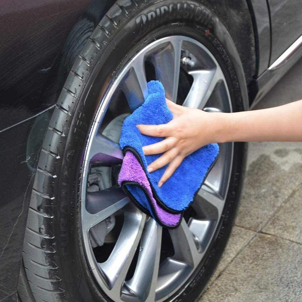 A person wiping their tire with a cloth