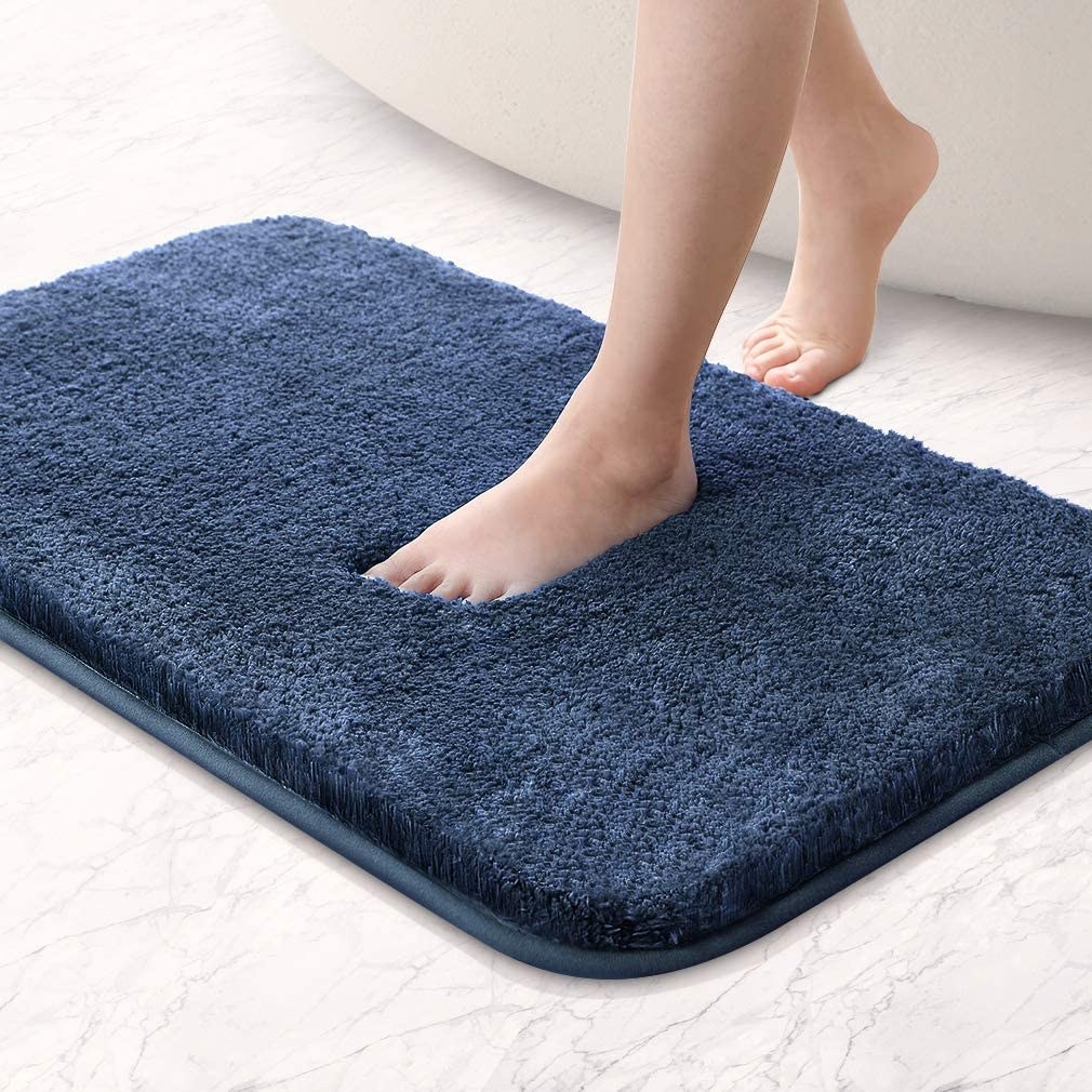 A person stepping onto the bath mat