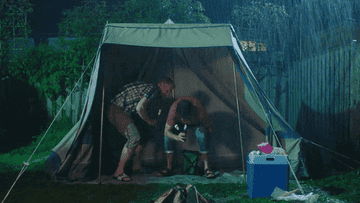 Two characters under a collapsing tent in the rain from a scene in the Dutch series De Regels Van Floor 