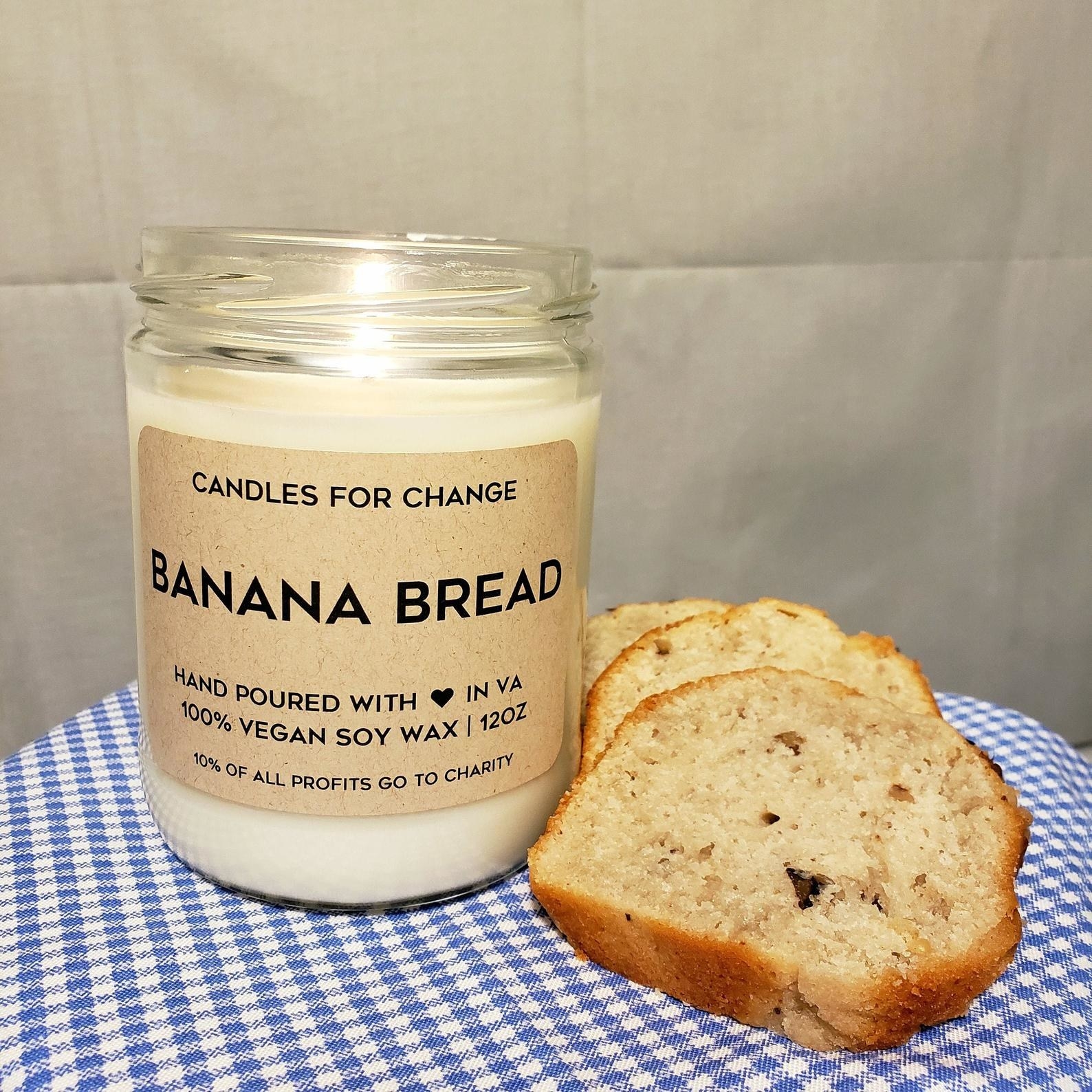 the banana bread candle on a gingham tablecloth next to slices of banana bread