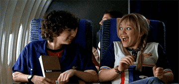 Gordo and Lizzie clapping on a plane