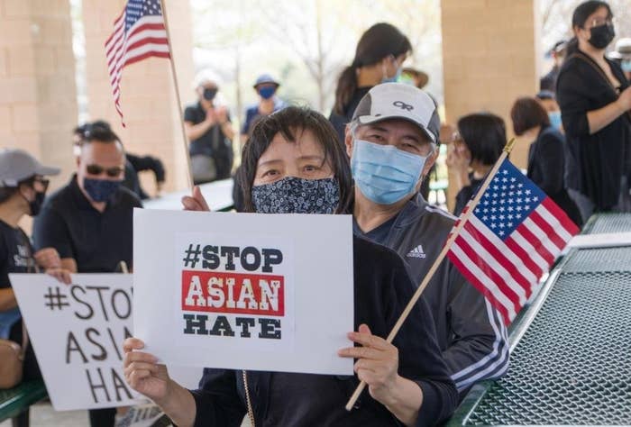 People holding #Stop Asian Hate posters and American flags