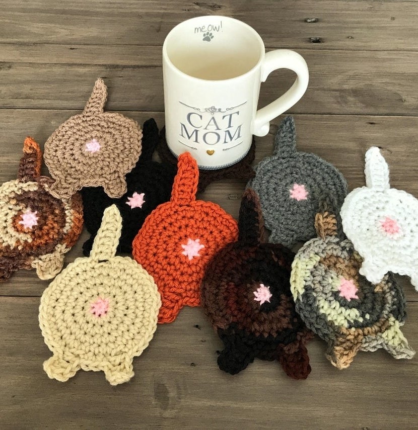 Several cat booty coasters in front of a mug
