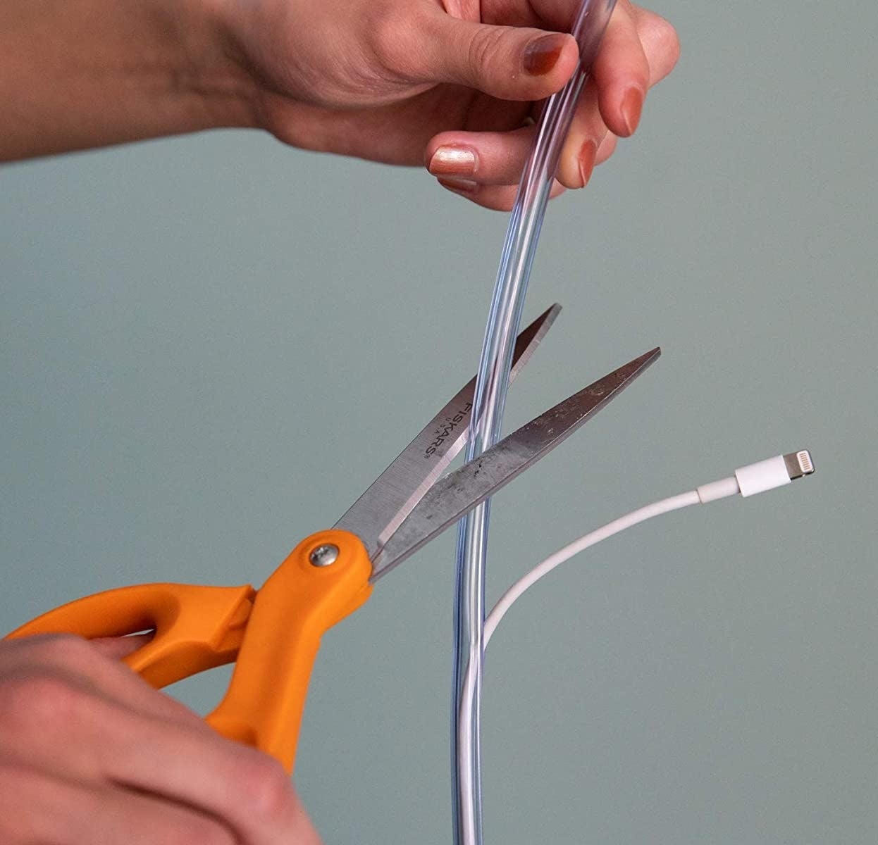 A person cutting a cord cover