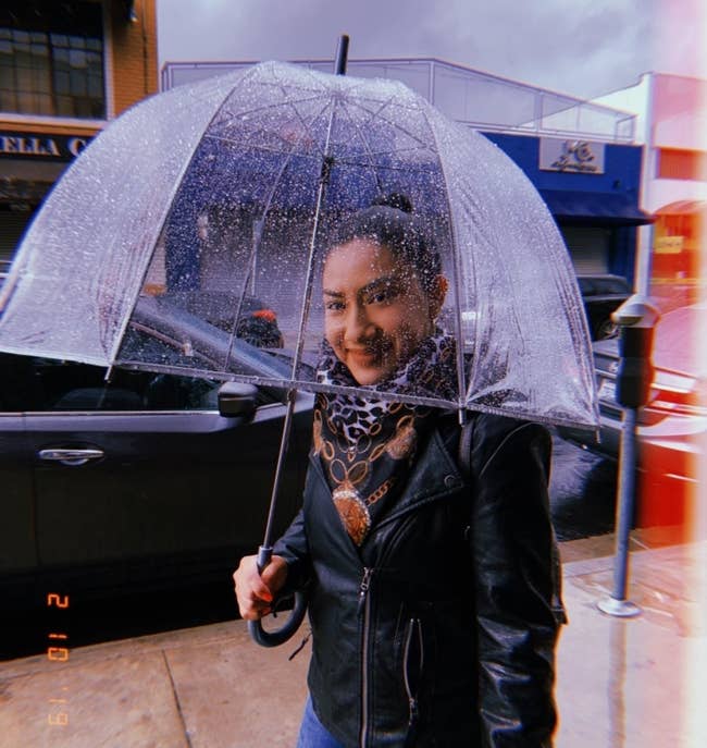 reviewer smiling through their clear umbrella 